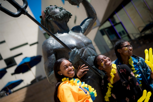 recent graduates in front of king triton statue