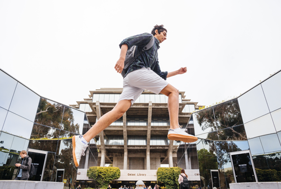 Student jumping in front of Geisel Library 
